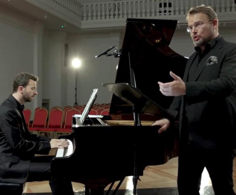 Bas-baryton Tomasz Konieczny śpiewa pieśni Moniuszki wspólnie z pianistą Lechem Napierałą, obaj artyści ubrani są w czarne stroje